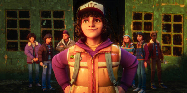"Animated kid with curly hair and a cap stands confidently in front of a group of friends outside an old, green, weathered building, all dressed in outdoor clothing, suggesting an adventurous setting."